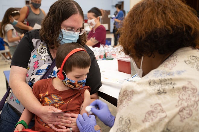 Jennifer Courter holds her son, David Courter, 5, as he receives a COVID-19 vaccination at John F. Long Elementary in Phoenix, Ariz. on Nov. 5, 2021.