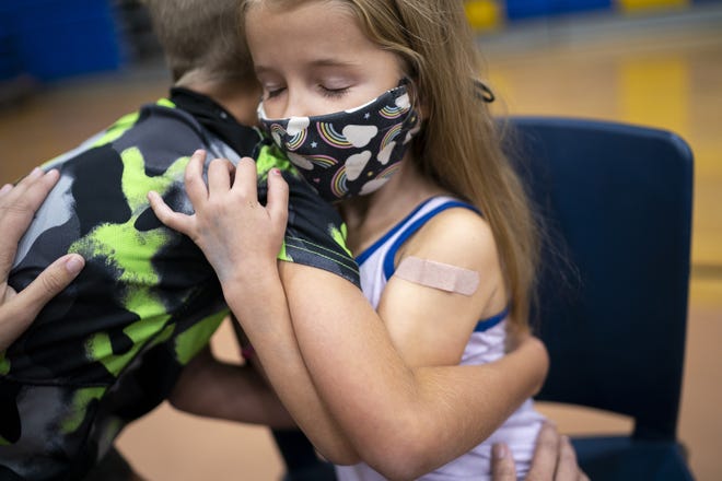 Hazel Talcott, 5, right, hugs her brother Huxley, 8, left, after receiving her first dose of the COVID-19 vaccine on Saturday, Nov. 6, 2021, at Carl Hayden Community High School in Phoenix.