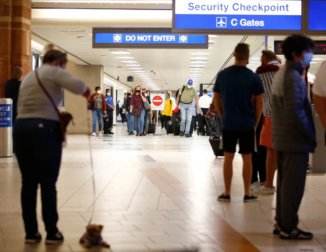 Travelers leave their gates at Phoenix Sky Harbor International Airport on Nov. 23, 2021, in Phoenix.