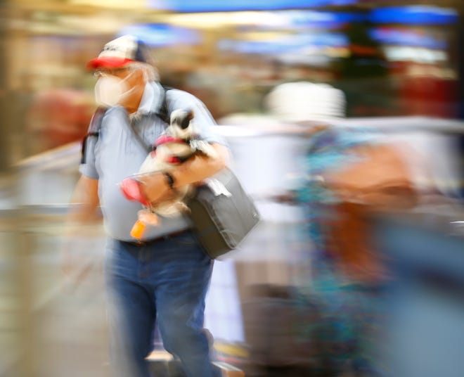 Travelers hustle their way to their gates in Terminal 4 at Phoenix Sky Harbor International Airport on Nov. 23, 2021, in Phoenix.