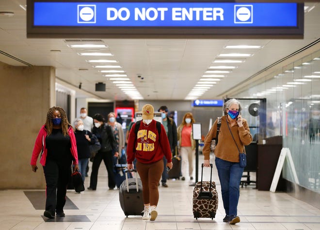 Passengers arrive at Phoenix Sky Harbor International Airport on Nov. 23, 2021, in Phoenix.