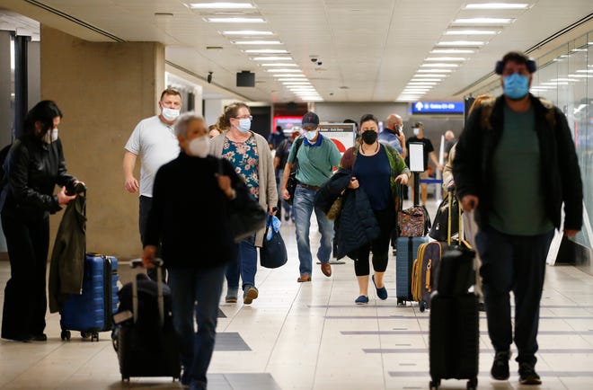 Passengers arrive at Phoenix Sky Harbor International Airport on Nov. 23, 2021, in Phoenix.