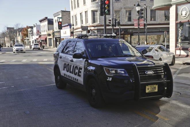 Un vehículo policial circula por Main Street donde se recogieron las pruebas y la ubicación de un desfile de Navidad, reabre al público en Waukesha, Wisconsin, EE. UU., 22 de noviembre de 2021.