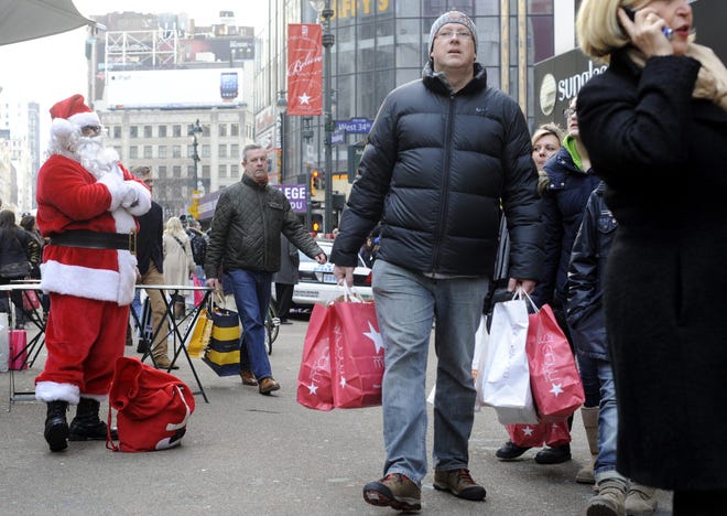Fotografía de archivo de un hombre que sostiene bolsas con sus compras.