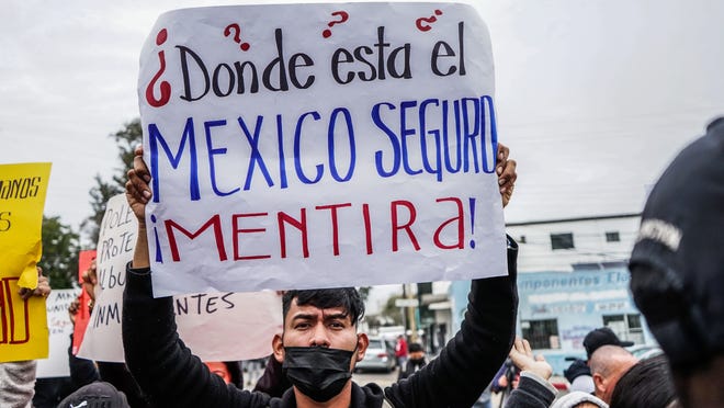 Migrantes de diversas nacionalidades se manifiestan por la falta de seguridad durante su paso por México, en un cuartel militar, el 21 de diciembre de 2021, en la ciudad de Tijuana, en Baja California (México).