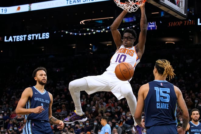 Phoenix Suns forward Jalen Smith (10) dunks over Memphis Grizzlies forwards Kyle Anderson (1) and Brandon Clarke during the first half of an NBA basketball game Monday, Dec. 27, 2021, in Phoenix.