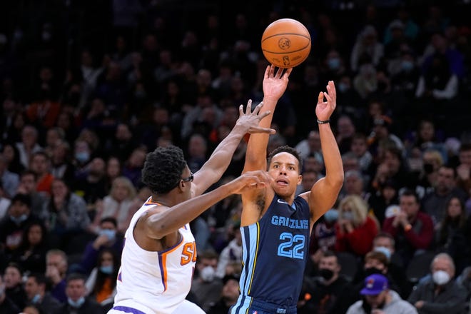 Memphis Grizzlies guard Desmond Bane (22) shoots over Phoenix Suns forward Jalen Smith during the second half of an NBA basketball game Monday, Dec. 27, 2021, in Phoenix. The Grizzlies won 114-113. (AP Photo/Rick Scuteri)