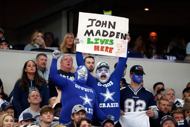 Dallas Cowboys fans hold up a John Madden sign during the first half of an NFL football game against the Arizona Cardinals Sunday, Jan. 2, 2022, in Arlington, Texas. (AP Photo/Michael Ainsworth)