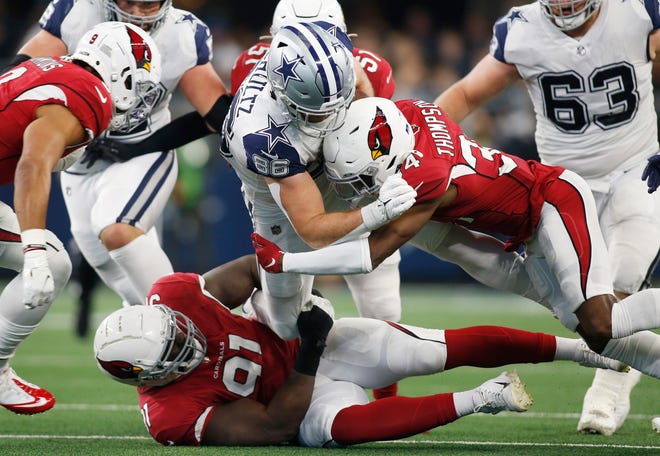 Jan 2, 2022; Arlington, Texas, USA; Dallas Cowboys tight end Dalton Schultz (86) is tackled by Arizona Cardinals free safety Jalen Thompson (34) and defensive end Michael Dogbe (91) in the first quarter at AT&T Stadium. Mandatory Credit: Tim Heitman-USA TODAY Sports