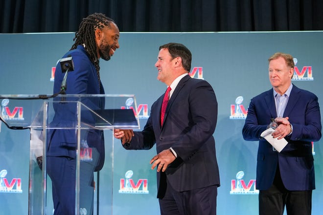 Doug Ducey, governor of Arizona, center, shakes hands with Larry Fitzgerald, former Cardinals wide receiver and executive chairperson of the Arizona Super Bowl host committee, left, as Roger Goodell, Commissioner of the NFL, looks on during the official Super Bowl Host Committee handoff press conference at the Los Angeles Convention Center on Monday, Feb. 14, 2022, in Los Angeles.