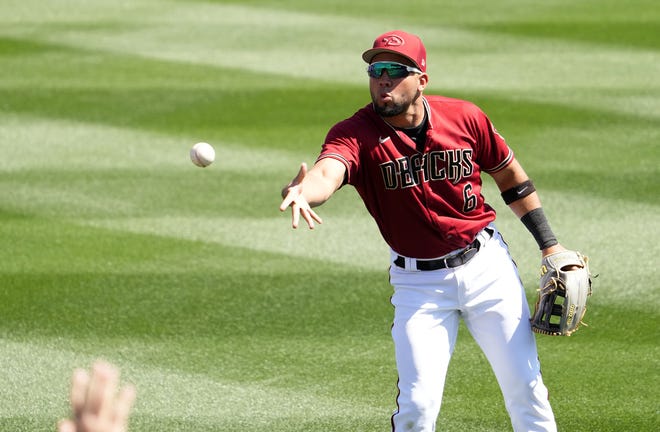 Arizona Diamondbacks left fielder Eduardo Diaz tosses a ball to the fans during a spring training game against the Colorado Rockies at Salt River Fields in Scottsdale on March 18, 2022.