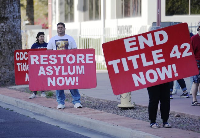 Manifestantes sostienen pancartas durante una protesta a favor de los solicitantes de asilo frente a las oficinas del ICE en Phoenix el 22 de marzo de 2022. Exigen que la Administración Biden ponga fin al Título 42 y deje de retener a los solicitantes de asilo ilegalmente en México.