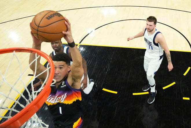 A; Phoenix Suns guard Devin Booker (1) dunks the ball against Dallas Mavericks guard Luka Doncic (77) during game one of the second round for the 2022 NBA playoffs at Footprint Center.