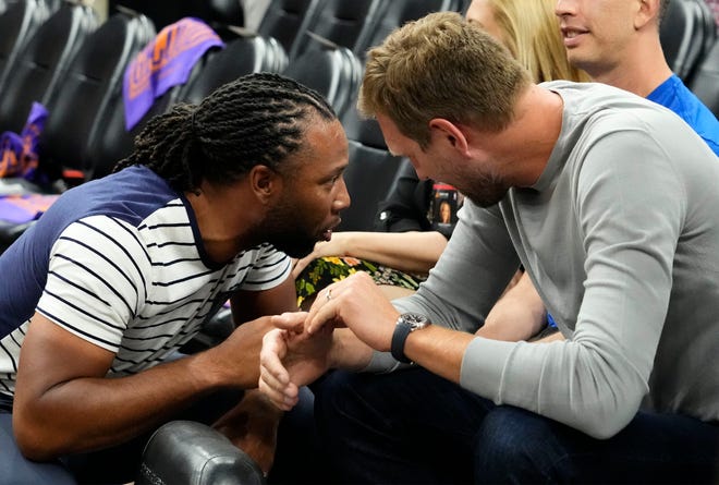 Larry Fitzgerald talks to former Mavericks center Dirk Nowitzki during game one of the second round for the 2022 NBA playoffs at Footprint Center.