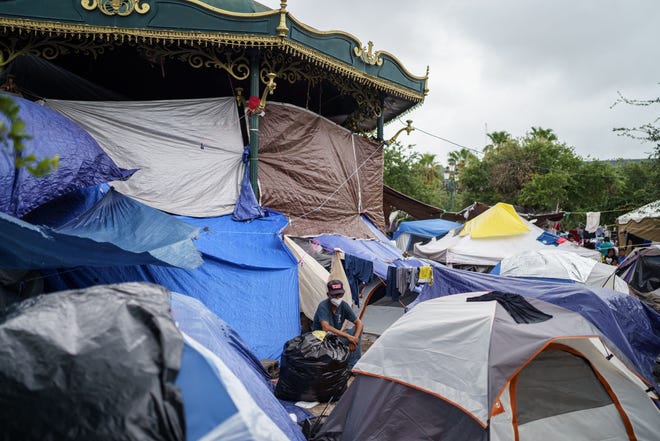 ARCHIVO -- Un hombre se sienta entre un mar de tiendas de campaña en un campamento improvisado de migrantes en la ciudad fronteriza de Reynosa, Tamaulipas, México, el 10 de julio de 2021. En el campamento viven unas 1,000 personas procedentes de Centroamérica y otros países latinoamericanos, con la esperanza de tener una oportunidad de entrar en Estados Unidos