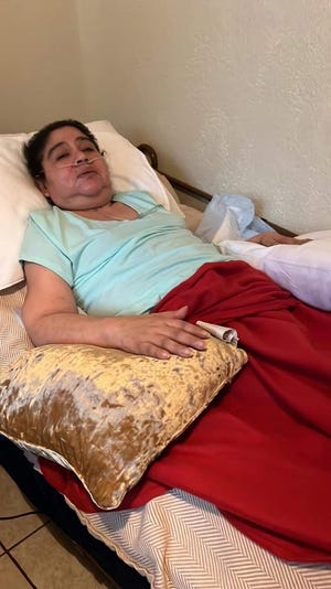 Fotografía familiar cedida donde aparece Verónica Ruiz, de 48 años, postrada en una cama y conectada a una máquina de oxígeno las 24 horas del día debido a su covid prolongado.
