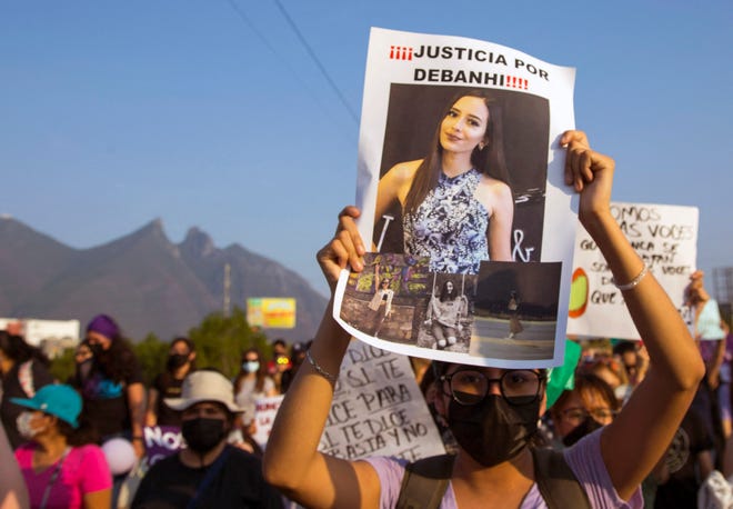 Una mujer sostiene un cartel con la foto de Debahi Escobar, quien fue encontrada muerta en Monterrey.
