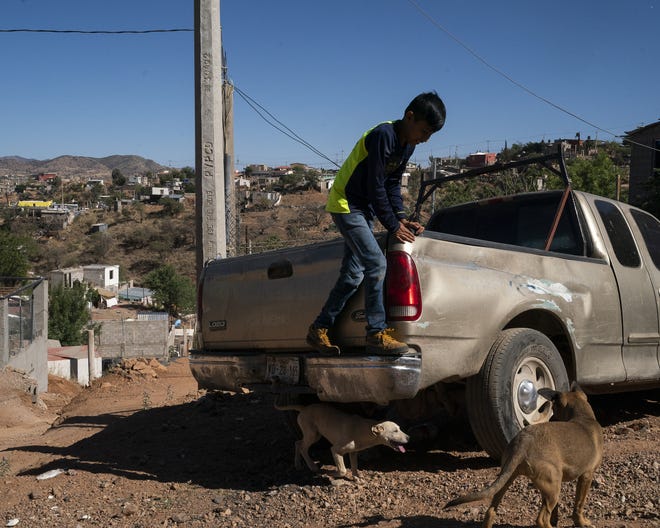 Cristian Lopez Velez, 11, tries to avoid stray dogs as he plays outside his home on the outskirts of Nogales on May 23, 2022. Cristian and his family moved from Guerrero to Nogales to apply for asylum after his family was threatened by the cartel. A federal judge in Louisiana ruled that Title 42, a Trump administration era public health order, must stay in place; making it difficult for migrants in Mexico to seek asylum to the U.S.