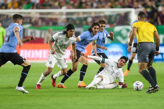 El defensa mexicano Edson Á lvarez (4), a la derecha, cae tras una falta durante el segundo tiempo entre M é xico y Uruguay en el State Farm Stadium el jueves 2 de junio de 2022, en Glendale.