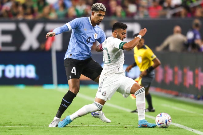 El delantero mexicano Alexis Vega (10), a la derecha, intenta regatear al defensa uruguayo Ronald Ara œ jo (4), a la izquierda, durante el primer tiempo entre M é xico y Uruguay en el State Farm Stadium el jueves 2 de junio de 2022, en Glendale.