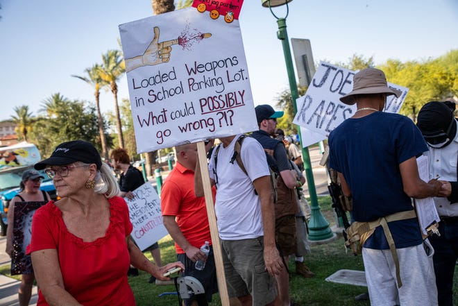 Bonnie Hopes is seen holding a sign in front of counter-protesters who attempted to disrupt the March for Our Lives demonstration outside the Arizona Capitol on June 11, 2022, in Phoenix.