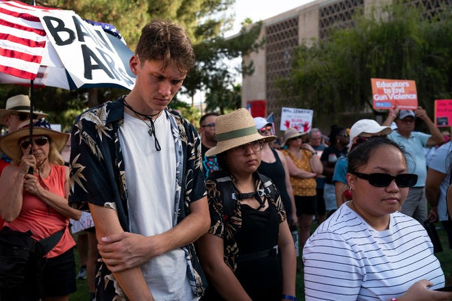 Nolan Lyle, left, joins in a moment of silence for victims of mass shootings during the annual March for Our Lives protest, a nationwide demonstration in support of gun control legislation, at the Arizona State Capitol on Saturday, June 11, 2022.