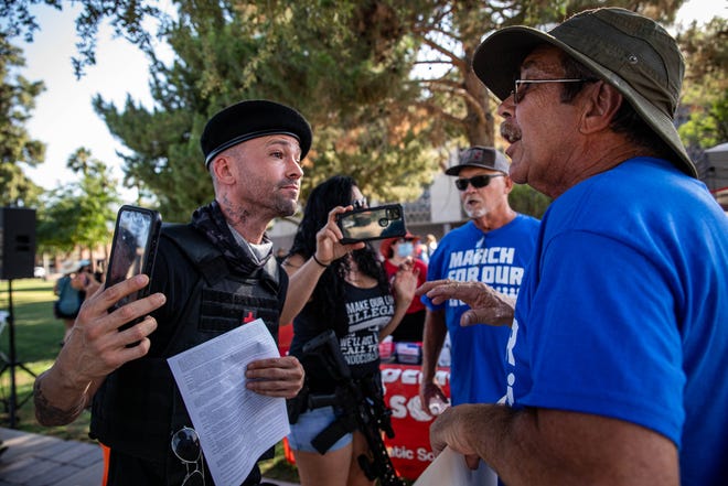 Joe Melone, a gun right activist (left), confronts a group of demonstrators outside the Arizona Capitol on June 11, 2022, in Phoenix.  Hundreds of people participated in the March for Our Lives demonstration calling for stricter gun laws in response to recent mass shootings.