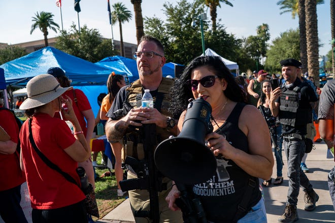 A group of counter-protesters carrying guns walks through a crowd at the Arizona State Capitol during the annual March for Our Lives protest, a nationwide demonstration in support of gun control legislation, on Saturday, June 11, 2022.