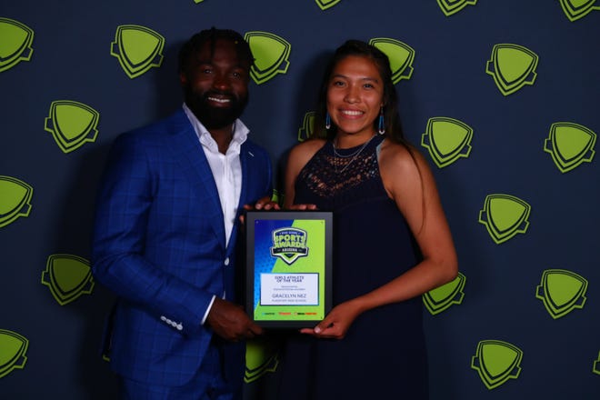 Gracelyn Nez of Flagstaff poses with Arizona Cardinals running back Eno Benjamin after winning the Girls Athlete of the Year honor at the 2022 Arizona High School Sports Awards show at ASU Gammage Theater.