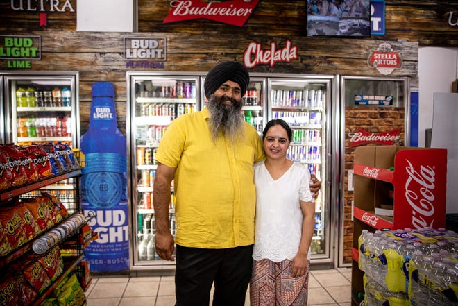 Jaswinder Singh and his wife Ramandeep Kaur pose for a portrait at the gas station they own on the corner of 20th Street and Osborn Road in Phoenix on June 21, 2022.