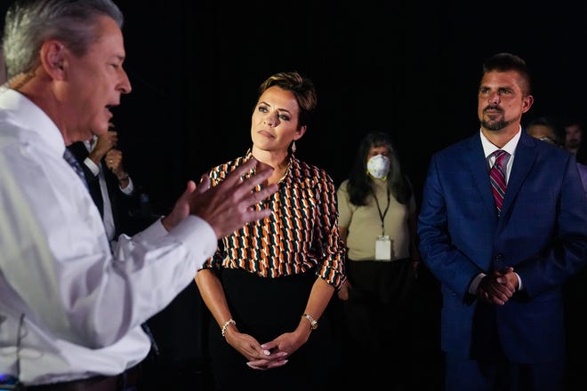 Kari Lake (center) and Scott Neely (right) listen as Ted Simons (left), moderator and Arizona PBS host, explains the rules before a debate with Republican candidates ahead of the Aug. 2 primary election for the Arizona governor's office in Phoenix.