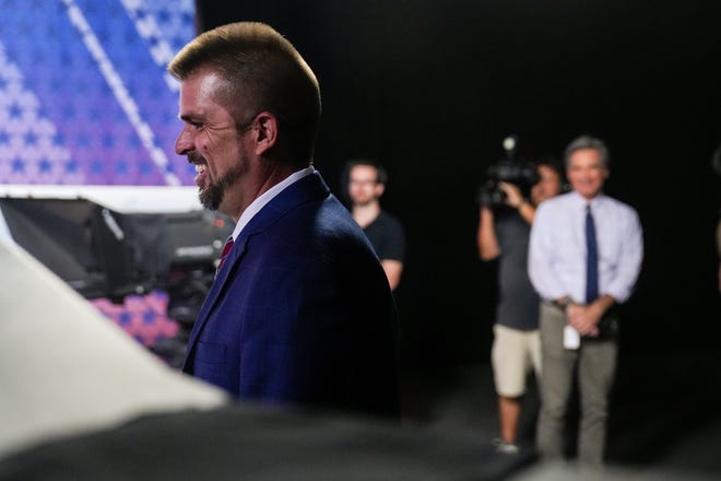Scott Neely walks to his seat before a debate with Republican candidates ahead of the Aug. 2 primary election for the Arizona governor's office  in Phoenix.