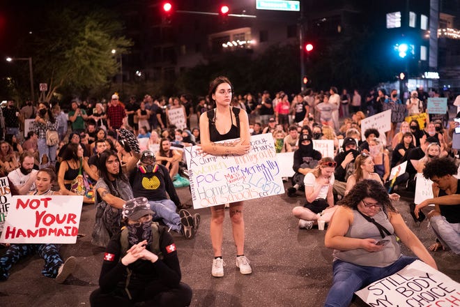 Jayda Fairfield, center, stands as speakers chant as protesters occupy the corner of Third and Roosevelt Streets during a march in support of abortion rights on Friday, July 1, 2022, in Phoenix.