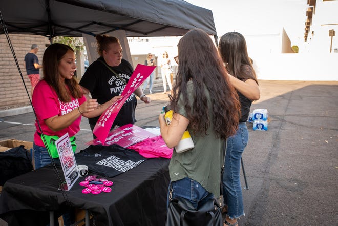 Volunteers hand out signs as a show of support for abortion rights at a storytelling event organized by the local chapter of Planned Parenthood in Phoenix on July 25, 2022.