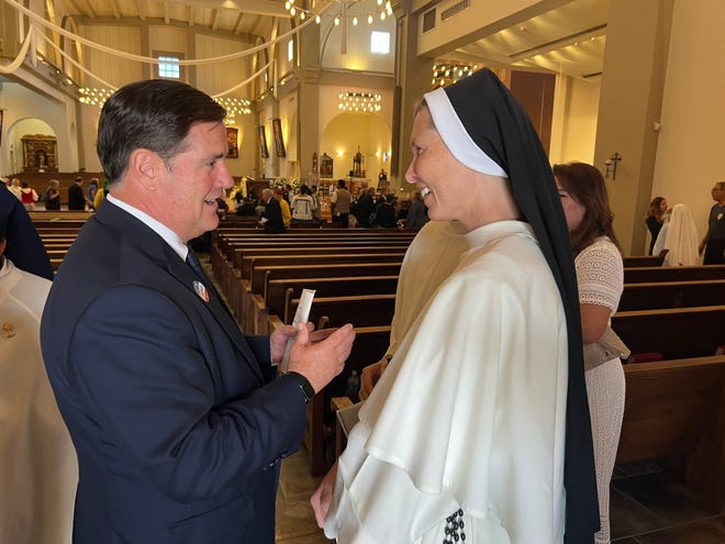 Arizona Gov. Doug Ducey speaks with an attendee as Bishop John Dolan is installed as the fifth Bishop of the Phoenix Diocese on Aug. 2, 2022.