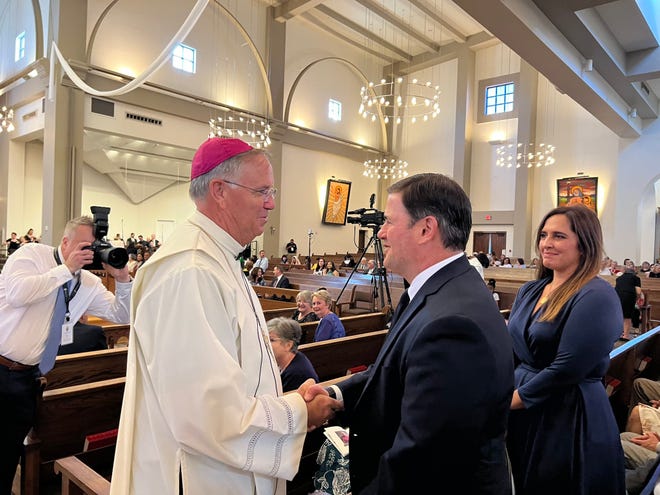Arizona Gov. Doug Ducey shakes the hand of Bishop John Dolan as he is installed as the fifth Bishop of the Phoenix Diocese on Aug. 2, 2022.