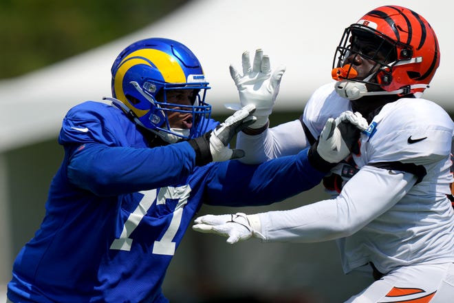 Los Angeles Rams offensive tackle AJ Jackson (77) and Cincinnati Bengals defensive end Cam Sample (96), right, participate in drills during a joint practice, Wednesday, Aug. 24, 2022, at the Paycor Stadium practice fields in Cincinnati.