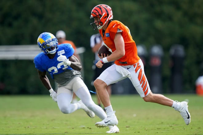Cincinnati Bengals quarterback Joe Burrow (9) runs out of the pocket as Los Angeles Rams running back Kyren Williams (23) defends during a joint practice, Wednesday, Aug. 24, 2022, at the Paycor Stadium practice fields in Cincinnati.