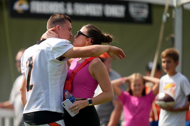 Cincinnati Bengals place kicker Evan McPherson (2) kisses his wife, Gracie, after a joint practice with the Los Angeles Rams, Wednesday, Aug. 24, 2022, at the Paycor Stadium practice fields in Cincinnati.