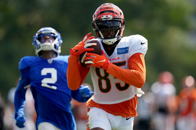Cincinnati Bengals wide receiver Tee Higgins (85) runs downfield after completing a deep pass down the sideline as Los Angeles Rams cornerback Troy Hill (2) reacts  during a joint practice with the Los Angeles Rams, Wednesday, Aug. 24, 2022, at the Paycor Stadium practice fields in Cincinnati.