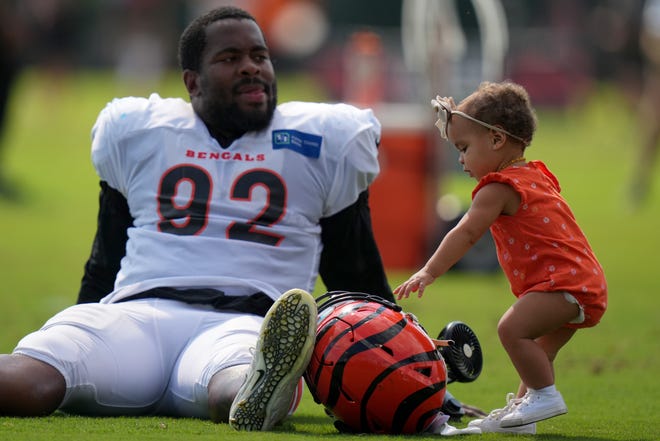 Cincinnati Bengals defensive tackle B.J. Hill’s (92) daughter reachers for his helmet after a joint practice with the Los Angeles Rams, Wednesday, Aug. 24, 2022, at the Paycor Stadium practice fields in Cincinnati.
