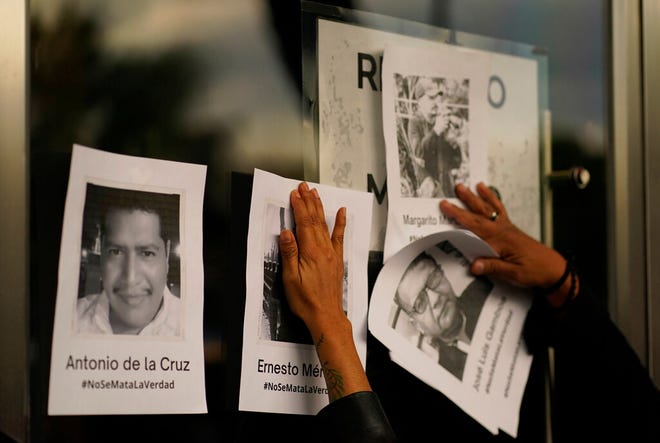 Demonstrators put up photos of slain journalists after the murder of journalist Fredid Roman during a vigil to protest the crime outside Mexico's Attorney General's office in Mexico City, Wednesday, Aug. 24, 2022. Roman was the 15th media worker killed so far this year in Mexico, where it is now considered the most dangerous country for reporters outside a war zone. (AP Photo/Eduardo Verdugo)