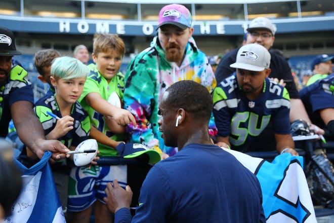 Geno Smith #7 of the Seattle Seahawks signs autographs before a game against the Arizona Cardinals at Lumen Field on October 16, 2022, in Seattle, Washington.