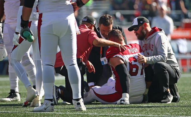 Justin Pugh #67 of the Arizona Cardinals is looked at by medical staff after being injured against the Seattle Seahawks at Lumen Field on October 16, 2022, in Seattle, Washington.