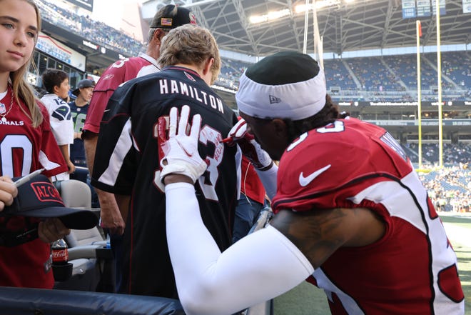 Antonio Hamilton #33 of the Arizona Cardinals signs an autograph for a fan prior to the game against the Seattle Seahawks at Lumen Field on October 16, 2022, in Seattle, Washington.
