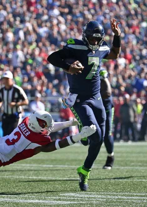 Geno Smith #7 of the Seattle Seahawks runs against Byron Murphy Jr. #7 of the Arizona Cardinals during the first half at Lumen Field on October 16, 2022, in Seattle, Washington.