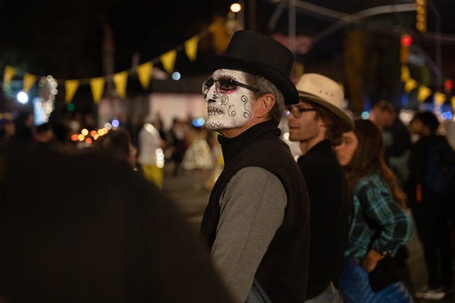 Steve Fiske watches the 33rd Annual All Souls Procession in Tucson on Nov. 6, 2022. The procession is not a Day of the Dead-themed celebration, but an opportunity for community members to honor the dead through any tradition, said event parent organization and nonprofit Many Mouths One Stomach.