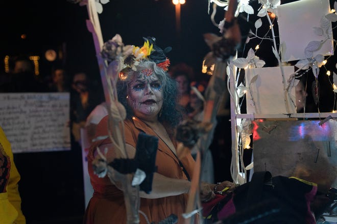 Lupita Chavez stands by her cart at the 33rd Annual All Souls Procession in Tucson on Nov. 6, 2022. Chavez said her dress was made with her daughter and niece and features three generations of her family.