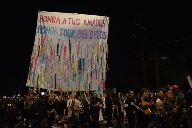 People walk at the 33rd Annual All Souls Procession in Tucson on Nov. 6, 2022. The procession is not a Day of the Dead-themed celebration, but an opportunity for community members to honor the dead through any tradition, said event parent organization and nonprofit Many Mouths One Stomach.