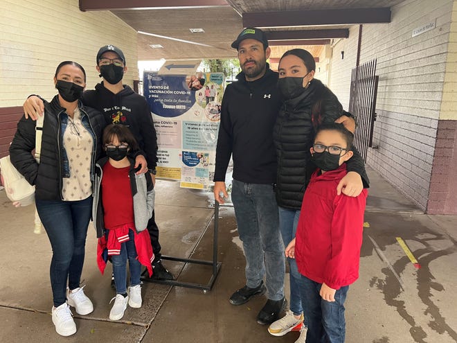 Erika Ruiz, 43, left, and her husband, Enrique Lopez, 43, immigrants from Mexico, and their four children, from left, Osiel Lopez, 15, Yaredh Lopez, 8, Grettell Lopez, 17, and Marlon Lopez, 7, received free shots at an event at St. Vincent de Paul Catholic School on Nov. 9, 2022, sponsored by the Maricopa County Department of Public Health.
